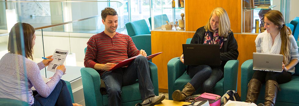 Four students sitting around a low table studying together.